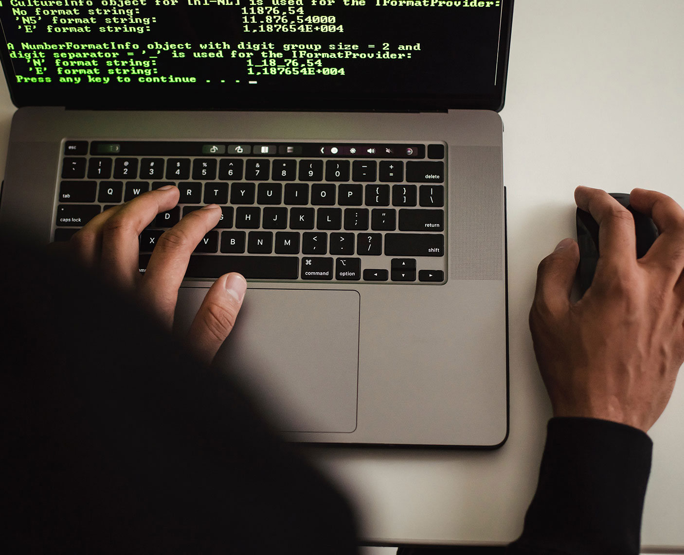 blog-3 Bild zeigt zwei Arme eines Mannes, der auf einer Computer-Tastatur und einer Maus arbeitet.
