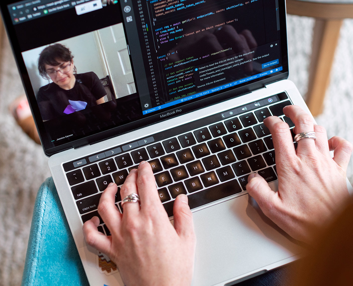 blog-6 Laptop mit zwei Händen. Am Bildschirm sieht man einen Videocall und einen Ausschnitt von Code-Schnippsel